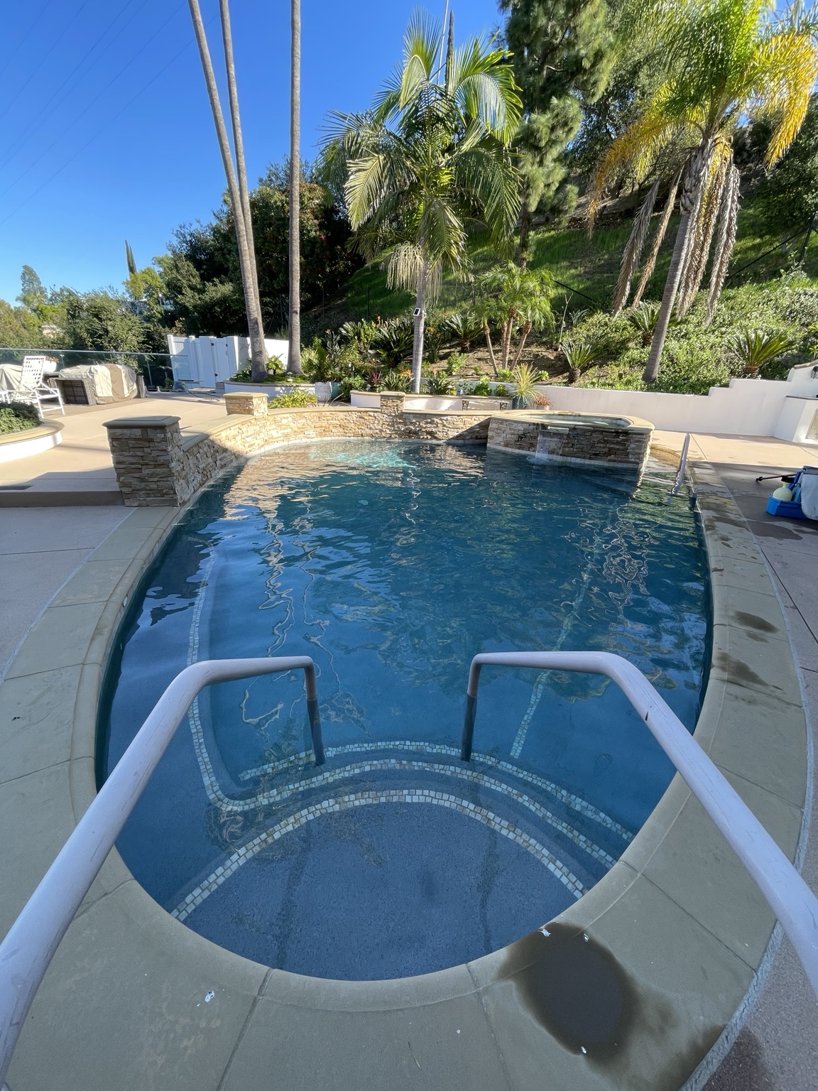 Real residential pool with a natural stone wall and water features