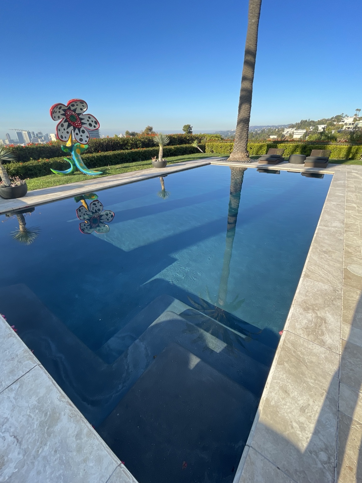 Residential infinity-edge pool with hillside views and blue water
